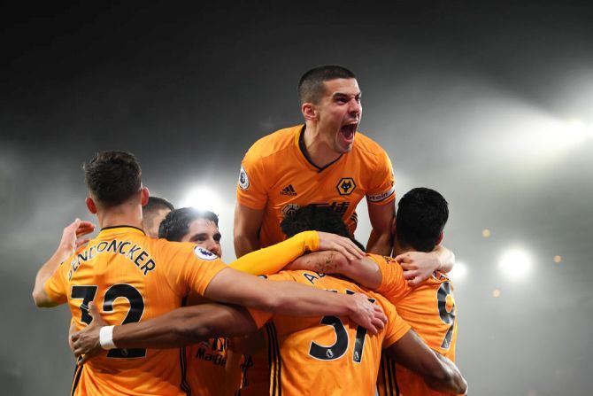 Wolverhampton Wanderers' Conor Coady jumps on his teammates as they celebrate Raul Jimenez's goal