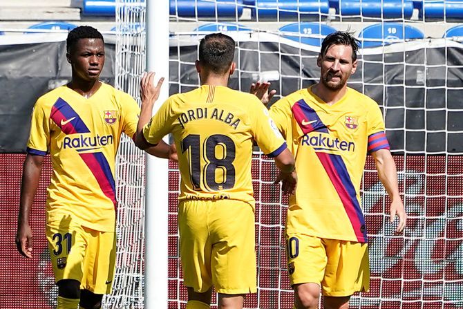 Barcelona's Lionel Messi celebrates with Jordi Alba and Ansu Fati after scoring their second goal against Deportivo Alaves at Estadio Mendizorroza, Vitoria-Gasteiz, Spain, on Sunday