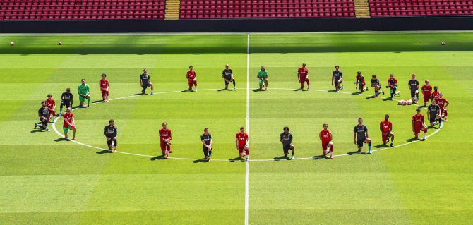 Liverpool FC players take a knee before their training session on Monday