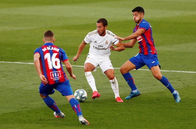 Real Madrid's Eden Hazard is challenged by Eibar's Pablo de Blasis