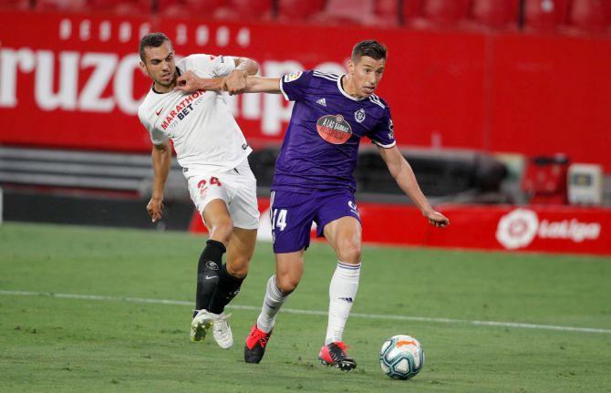 Sevilla's Joan Jordán challenges Valladolid's Ruben Alcaraz during their La Liga match at Estadio Ramon Sanchez Pizjuan in Seville, Spain