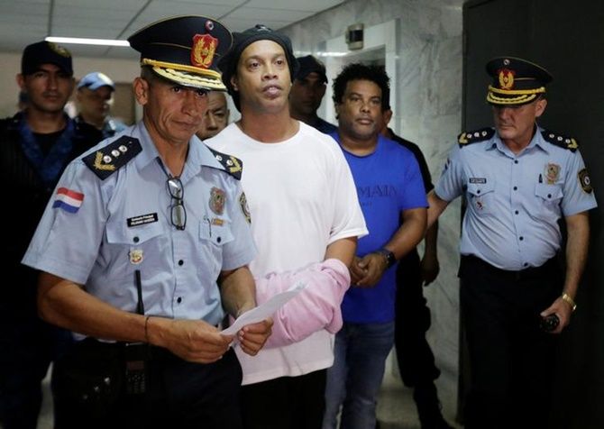 Ronaldinho and his brother Roberto de Asis handcuffed and escorted by police at the Supreme Court of Paraguay. 