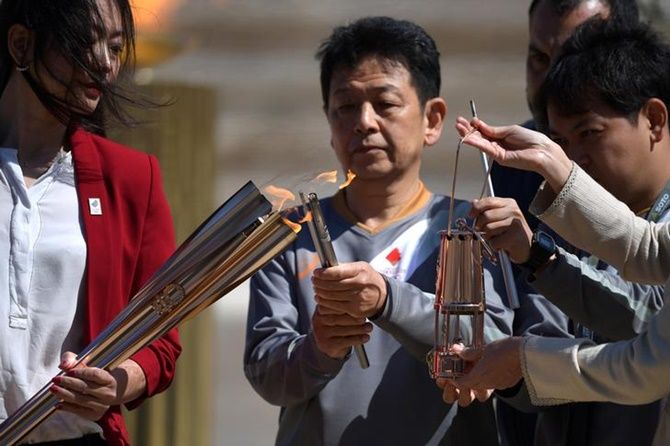 Former Japanese swimmer Imoto Naoko holds the Olympic torch during the Olympic flame handover ceremony for the 2020 Tokyo Summer Olympics at the Panathenaic Stadium, in Athens, Greece.