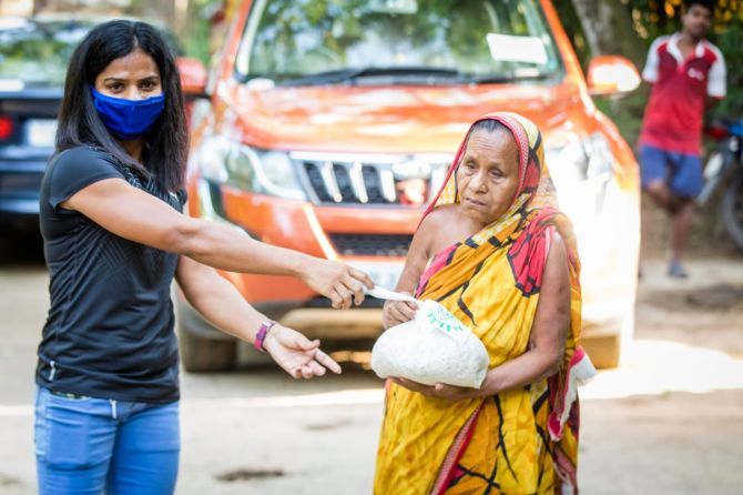 India's sprint queen Dutee Chand distributes food items to the needy in her village of Jajpur in Odisha 