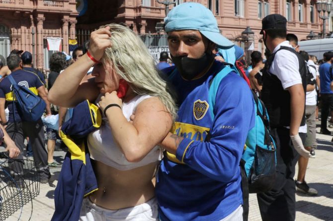 People walk away from Casa Rosada after riots break out during Diego Maradona's funeral