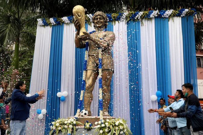 People shower petals on a statue of Diego Maradona during a prayer meeting to pay tribute to the Argentine soccer great in Kolkata on Thursday
