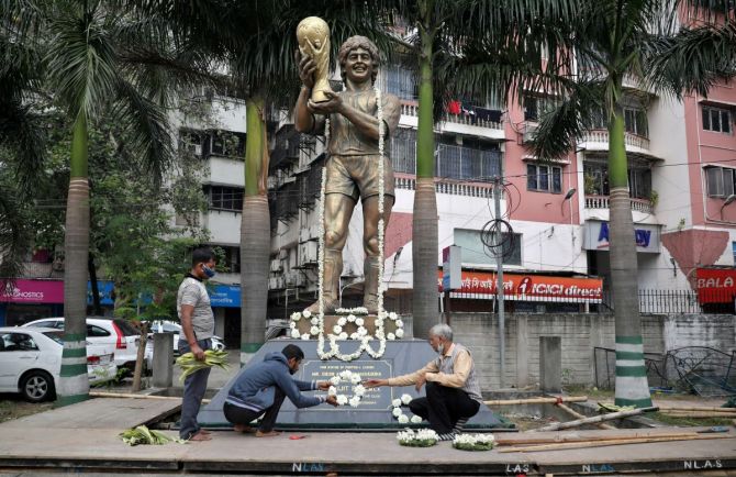 People decorate a statue of Argentine soccer great Diego Maradona before a prayer meeting, in Kolkata on Thursday 