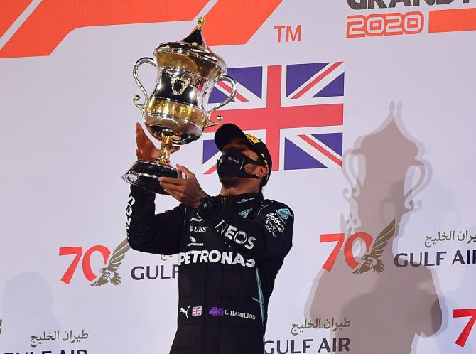  Mercedes driver Lewis Hamilton celebrates with a trophy on the podium after winning the Bahrain Grand Prix