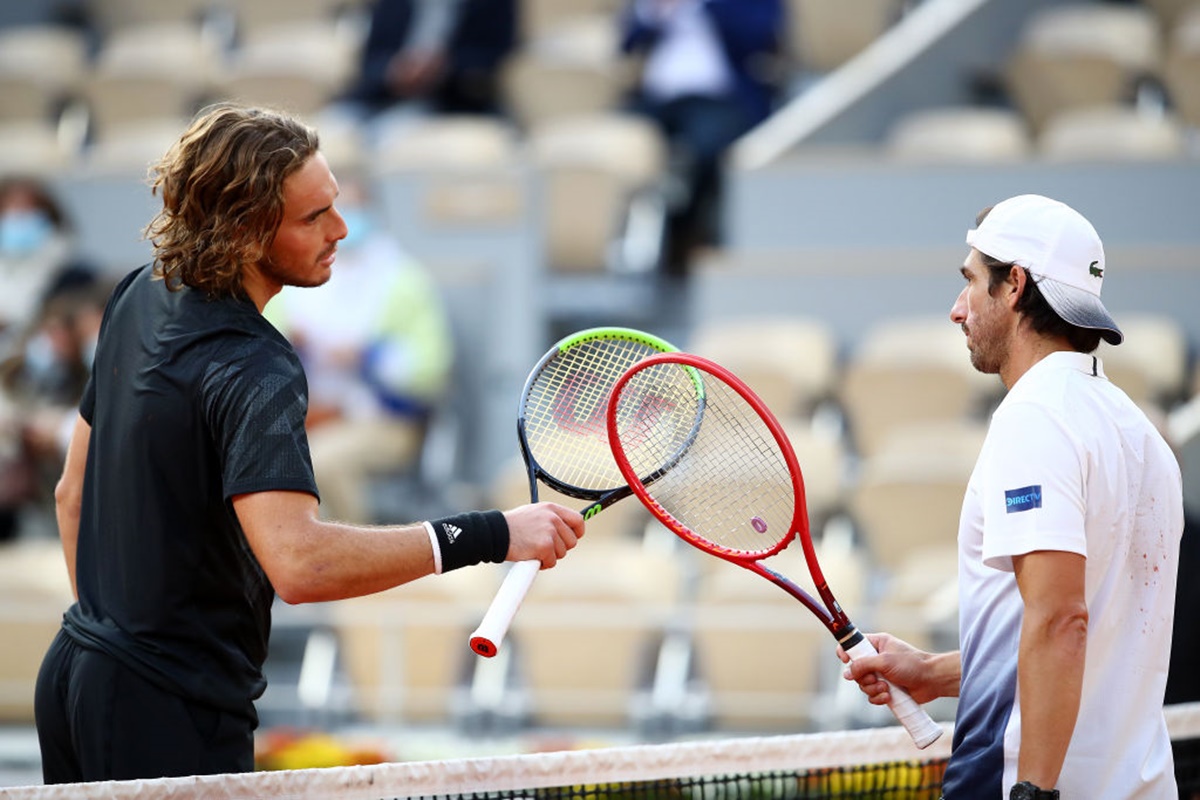 Greece's Stefanos Tsitsipas, left, knocks racquets at the net with Uruguay's Pablo Cuevasfollowing his straight sets victory.