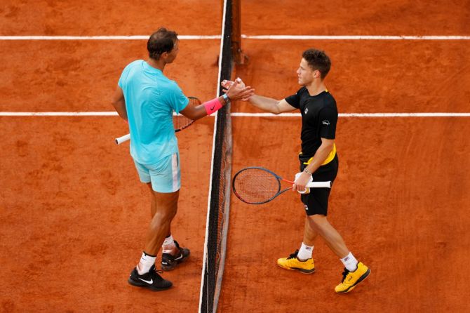 Rafael Nadal and Diego Schwartzman meet at the net after their match.