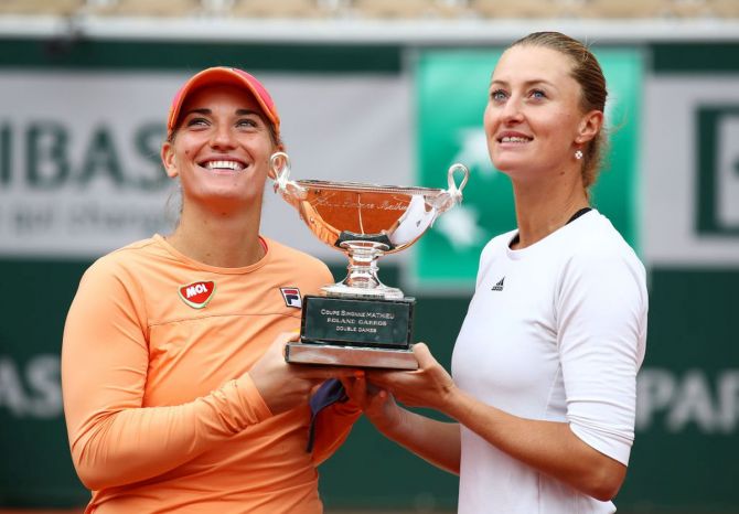 Hungary's Timea Babos (left) and France's Kristina Mladenovic pose with the winners trophy after winning the French Open women's doubles final on Sunday
