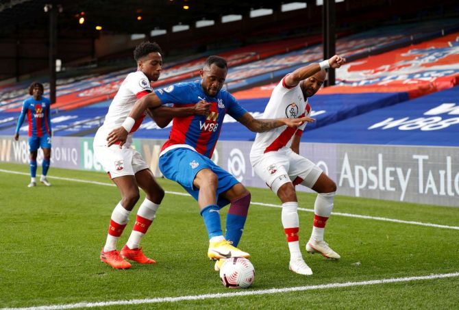 Crystal Palace's Jordan Ayew is challenged by Southampton's Kyle Walker-Peters and Nathan Redmond during their match at Selhurst Park in London