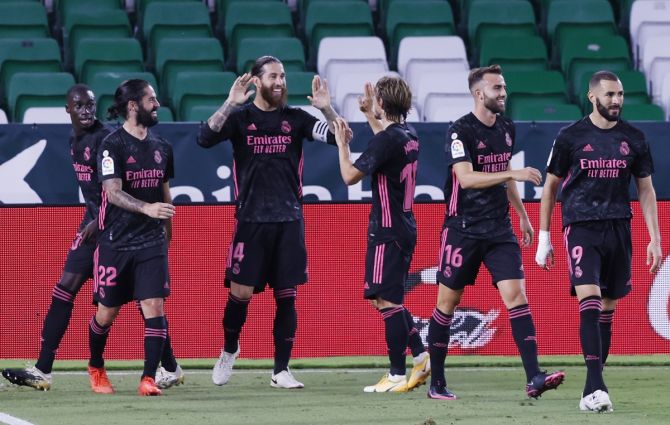 Sergio Ramos celebrates with teammates after scoring from the penalty spot to clinch victory for Real Madrid in their La Liga match against Real Betis
