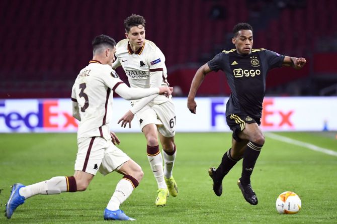 Ajax Amsterdam's Jurrien Timber in action with AS Roma's Ibanez and Riccardo Calafiori during their match at Johan Cruijff Arena, Amsterdam.