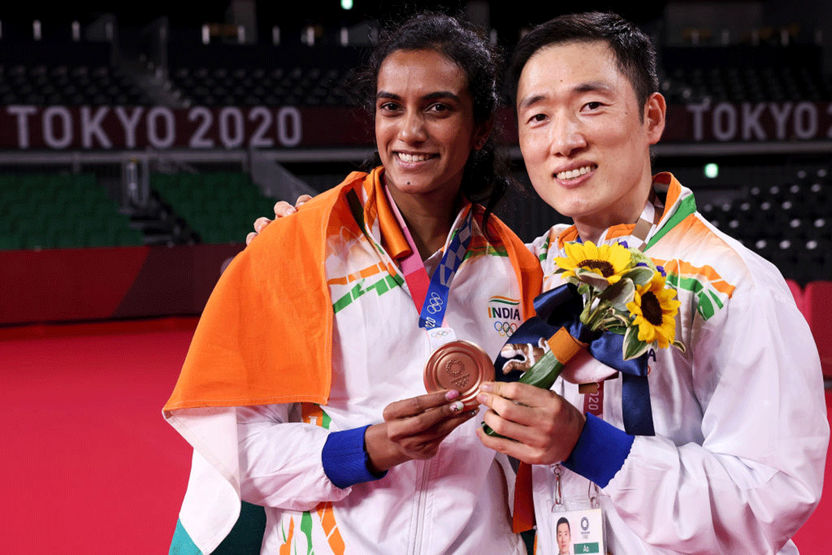 Tokyo Olympics Badminton bronze medallist PV Sindhu poses with her coach Park Tae-sang (right) during the medal ceremony at Musashino Forest Sport Plaza in Chofu, Tokyo, on Sunday