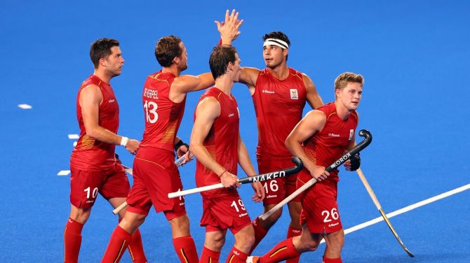 Alex Hendrickx celebrates with teammates after scoring for Belgium in the Olympics men's hockey quarter-final against Spain.