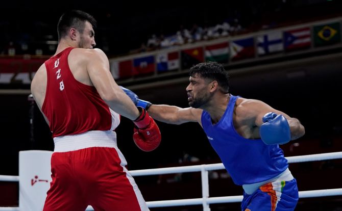 India's Satish Kumar exchanges punches with Uzbekistan's Bakhodir Jalolov (Red) during the Olympics men's Super Heavyweight (+91kg) quarter-final