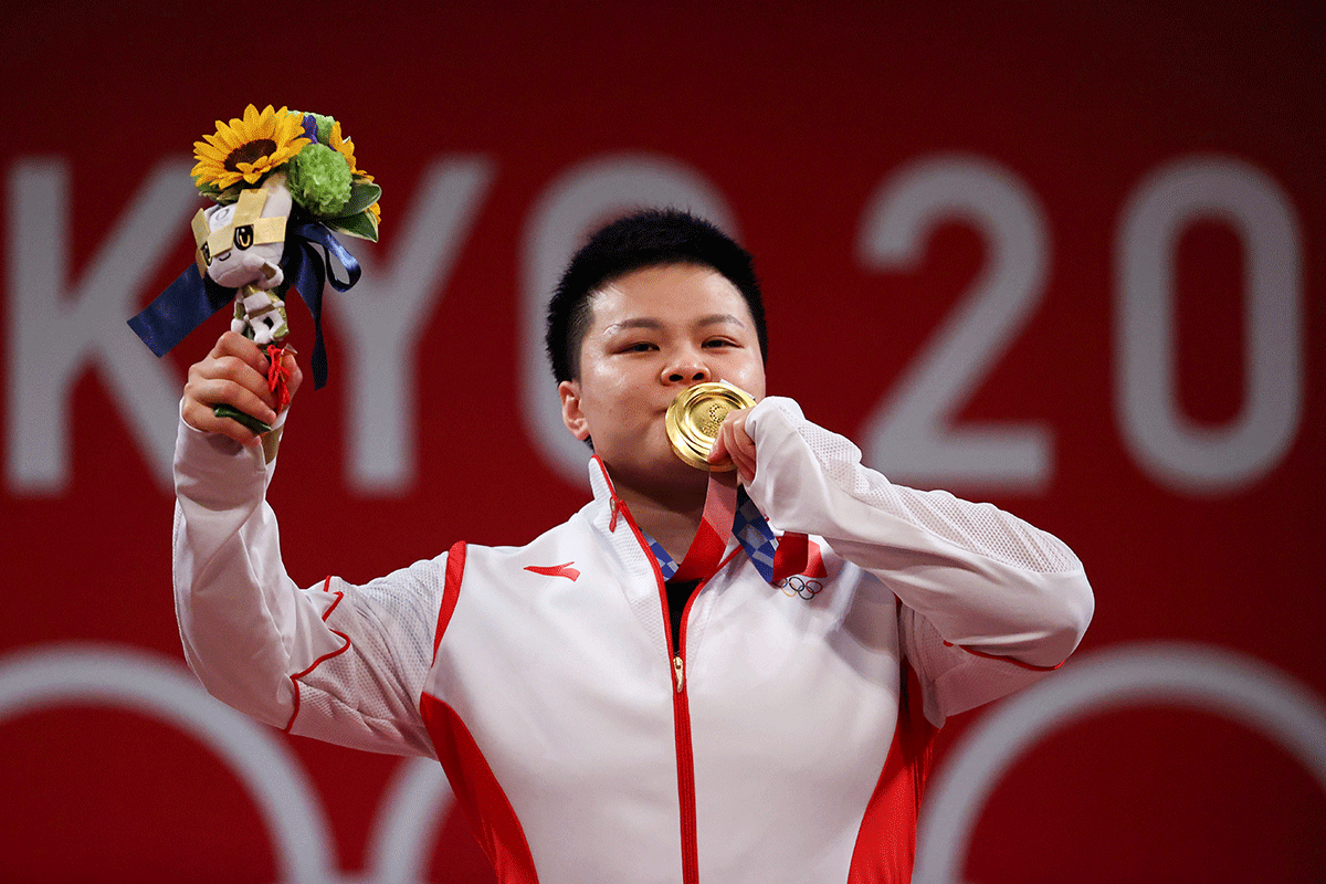 Gold medalist Wang Zhouyu of China celebrates on the podium after winning the Women's 87kg Weightlifting final on Monday