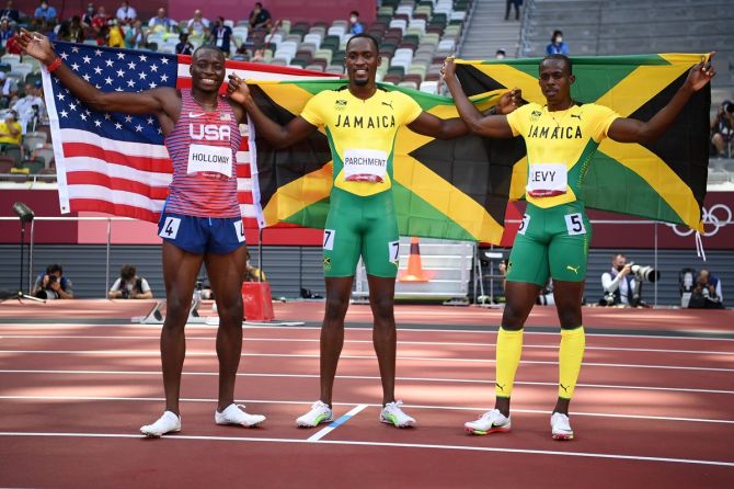 (L-R) Silver medalist Grant Holloway of the United States, gold medalist Hansle Parchment of Team Jamaica and bronze medalist Ronald Levy of Jamaica pose after competing in the Olympics men's 110m Hurdles final,  at Olympic Stadium in Tokyo, on Thursday. 