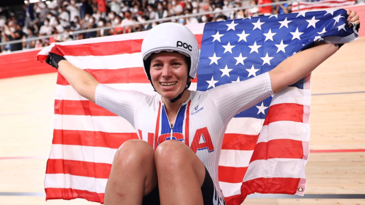 Jennifer Valente of the United States celebrates with the flag as she celebrates winning gold in the cycling track  Women's Omnium Points Race on Sunday