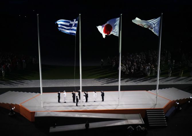 The flag of Greece, home of the Ancient Olympic Games, is raised alongside the flag of Japan and Olympic flag during the closing ceremony.
