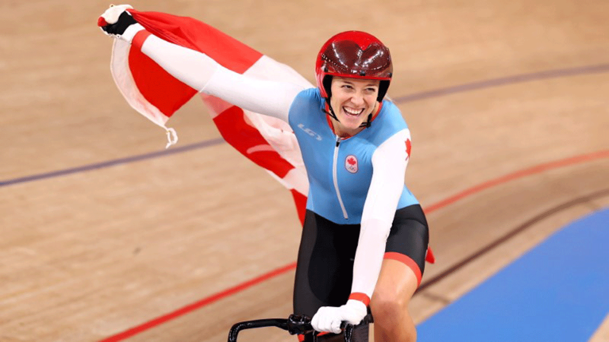 Canada's Kelsey Mitchell celebrates with a Canadian national flag after winning gold in the Cycling Track Women's Sprint final on Sunday