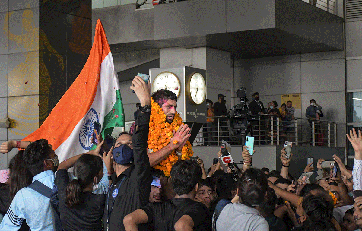 Silver medallist Ravi Dahiya is garlanded on his arrival