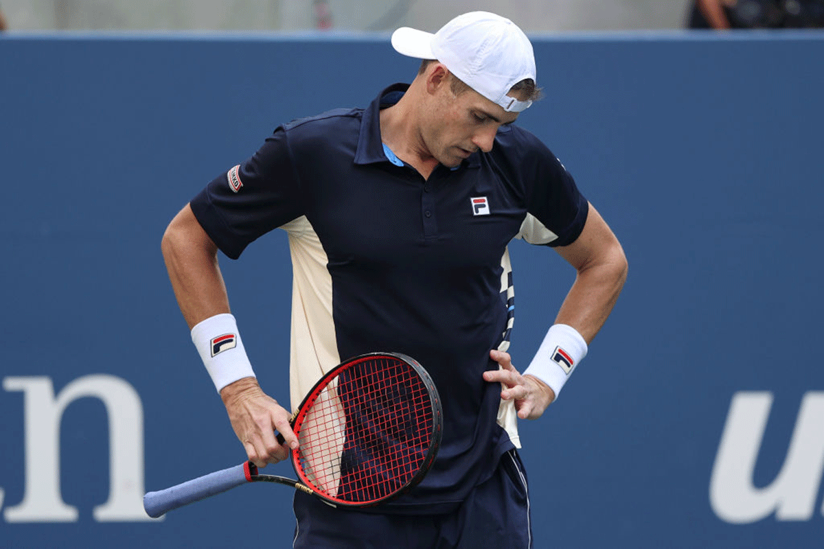 USA's John Isner reacts after losing a point against compatriot Brandon Nakashima