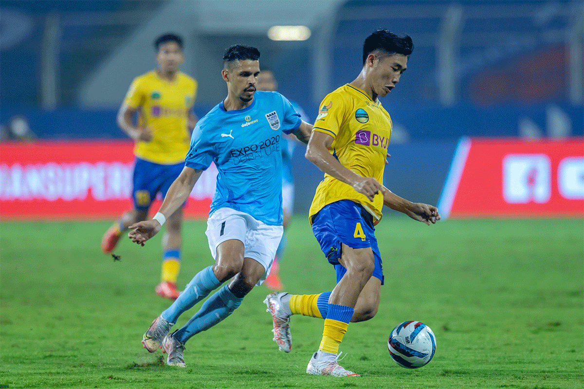 Kerala Blasters' Hormipam Ruivah runs past a Mumbai City FC player during their Indan Super League match in Margao on Sunday