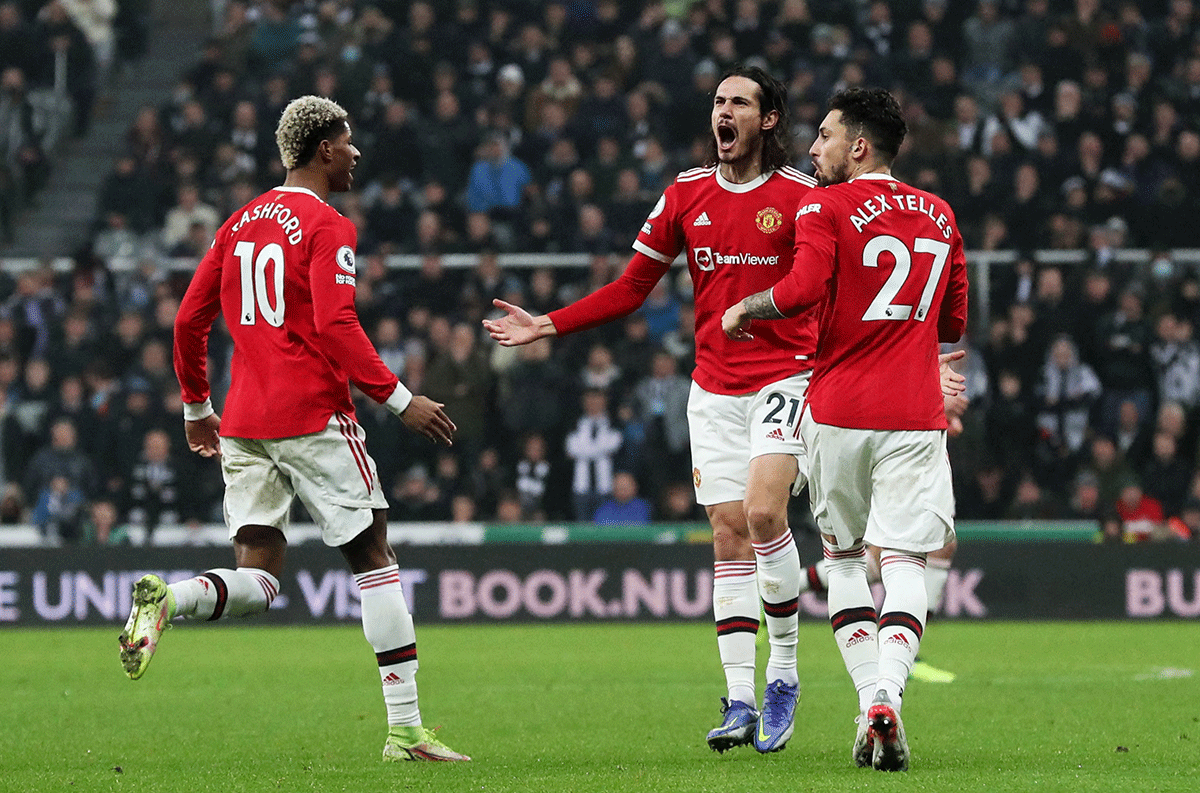 Manchester United's Edinson Cavani celebrates scoring their first goal with Alex Telles and Marcus Rashford during their English Premier League match against Newcastle United at St James' Park in Newcastle on Monday