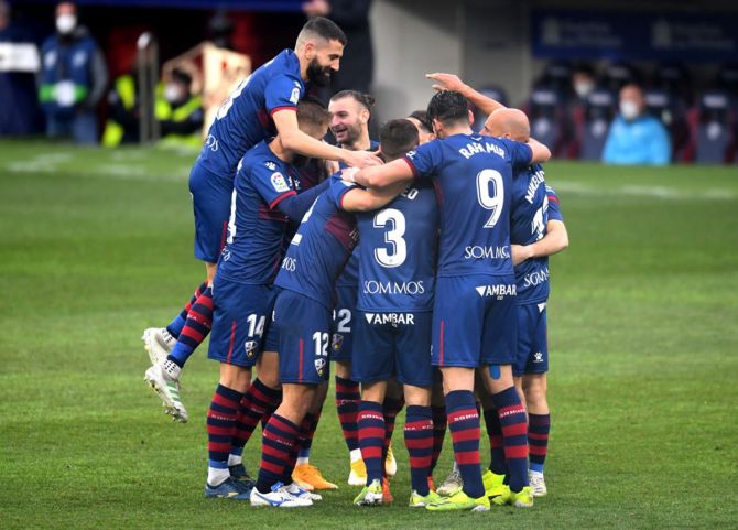 Javi Galan  celebrates with teammates after scoring for SD Huesca.