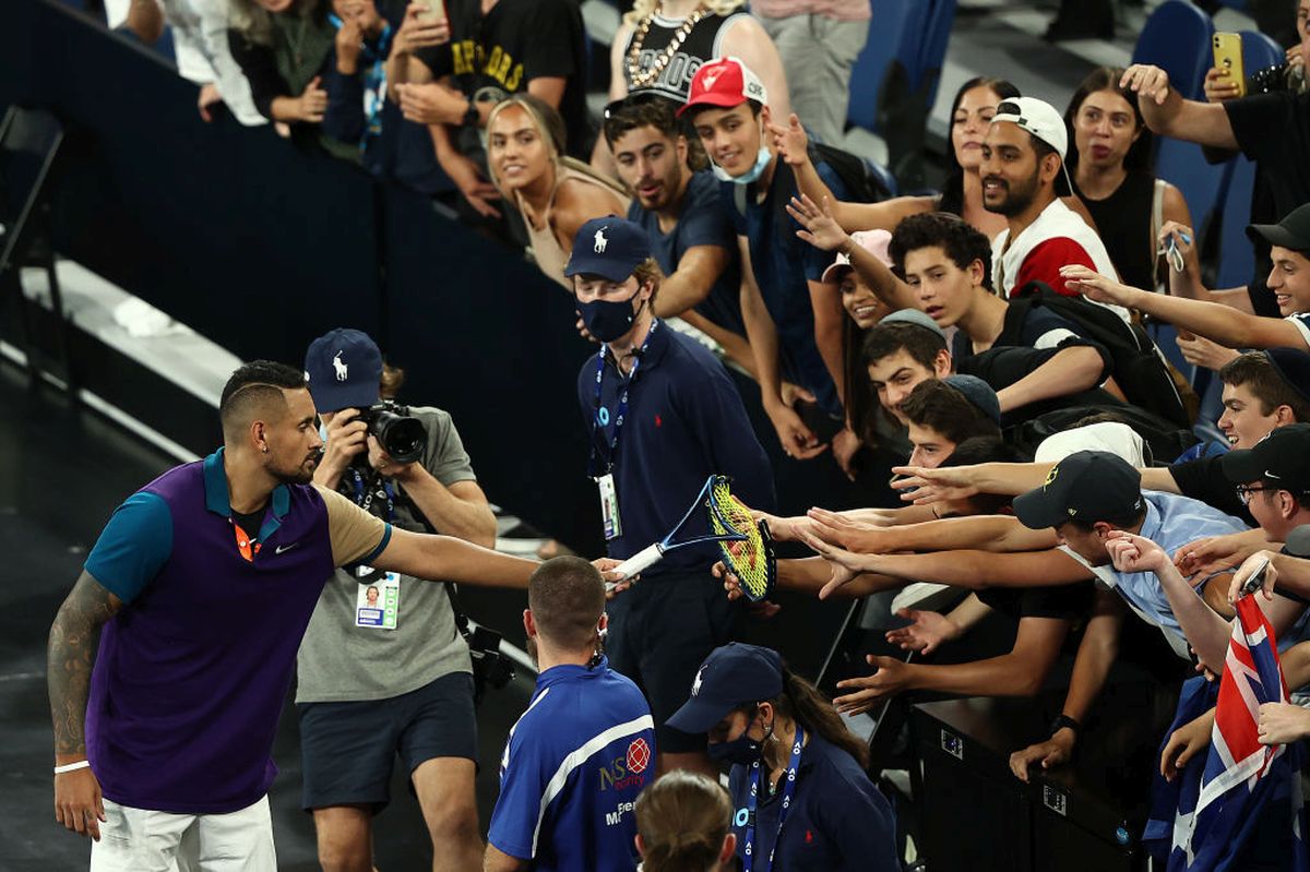 Australia's Nick Kyrgios gives his broken racket to fans after winning his Australian Open second round match against France's Ugo Humbert on Wednesday