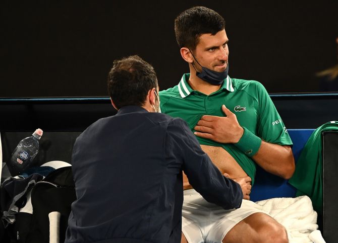Serbia's Novak Djokovic receives medical attention during his men's singles third round match against Taylor Fritz of the United States at the Australian Open on Friday.