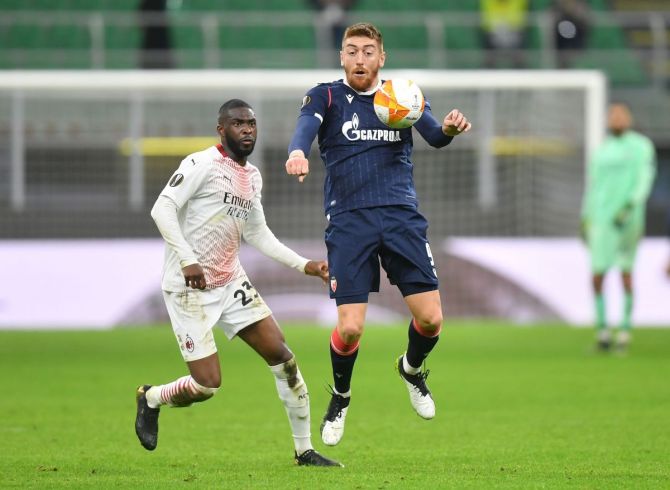 Crvena Zvezda's Milan Pavkov in action with AC Milan's Fikayo Tomori