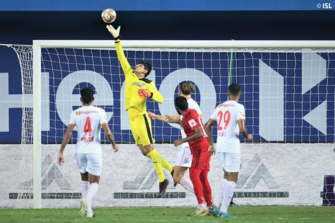 Bengaluru FC keeper Gurpreet Singh Sandhu leaps in the air to pull off a brilliant save in their ISL match against NEUFC at Vasco, Goa, on Tuesday.