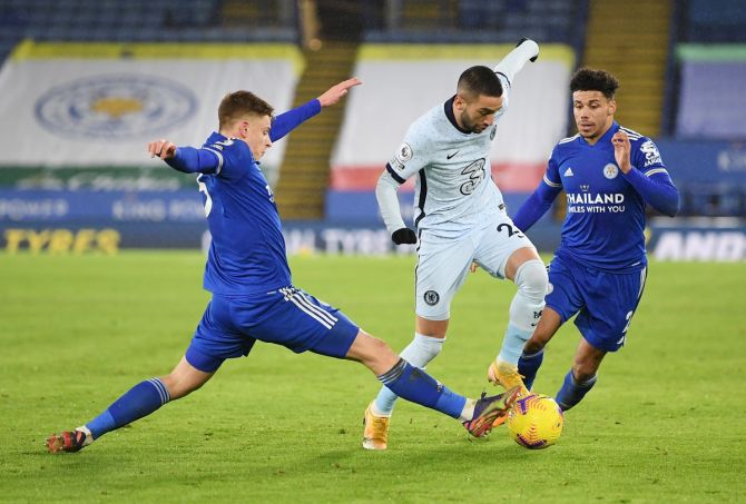 Chelsea's Hakim Ziyech tries to get past Leicester City's Harvey Barnes and James Justin. 