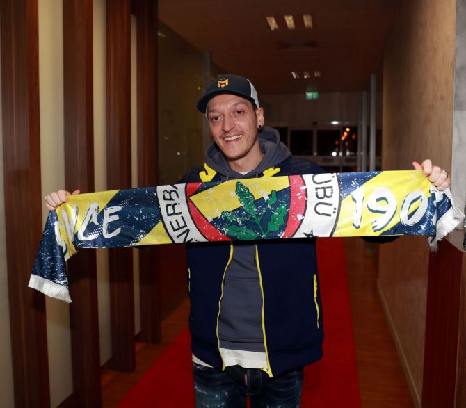 Mesut Ozil poses with a Fenerbahce scarf upon his arrival at Ataturk Airport in Istanbul, Turkey, January 18, 2021.