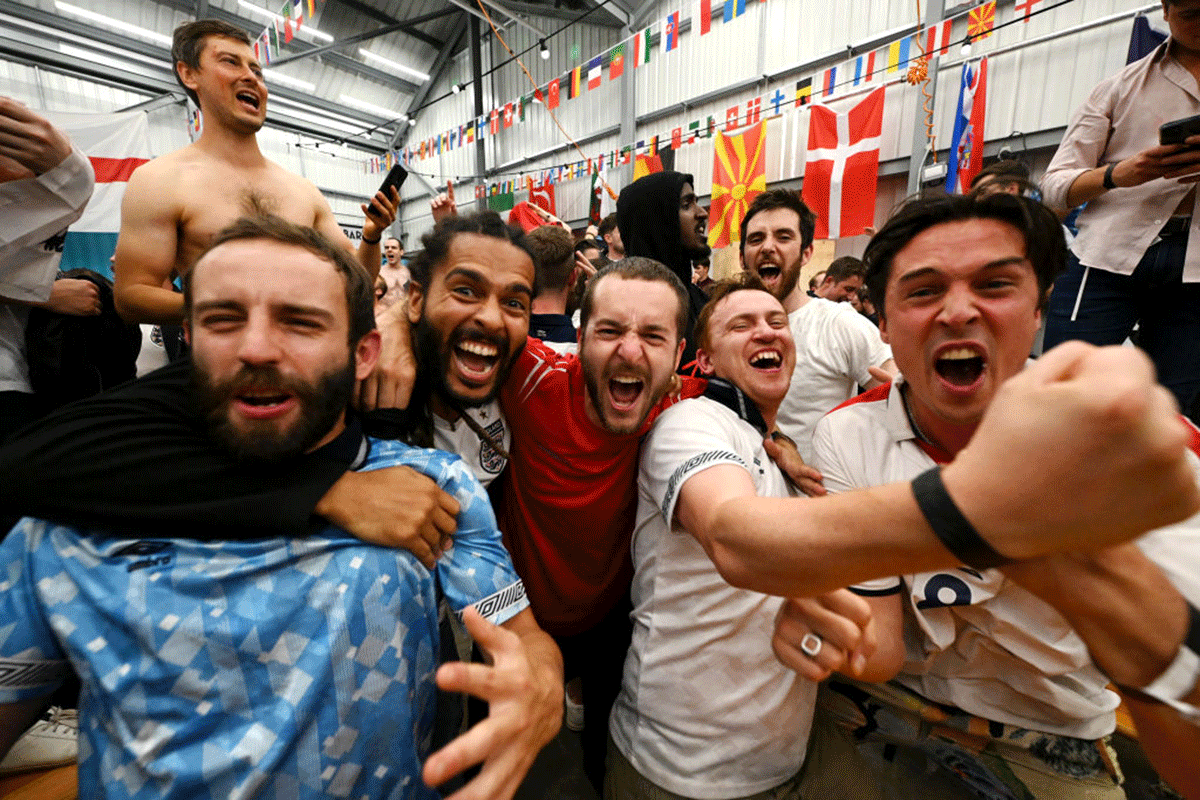 England fans celebrate as they watch a live broadcast of the semi-final match between England and Denmark at Hackney Bridge