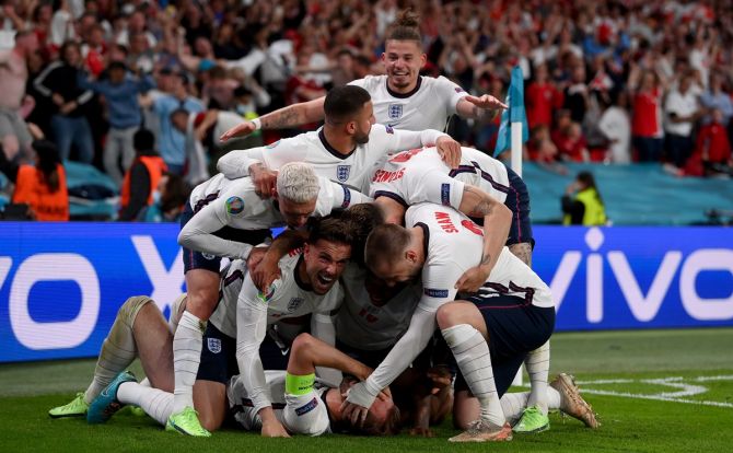 England's players celebrate after Harry Kane (obscured) scores following a penalty in the first period of extra-time, in the Euro 2020 semi-final against Denmark, at Wembley stadium in London, on Wednesday.