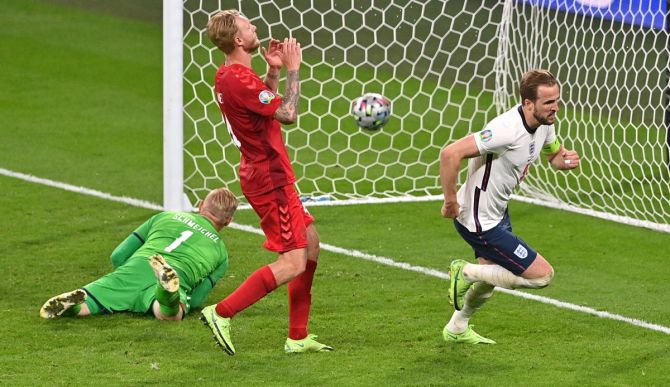 Harry Kane celebrates scoring from the rebound of his missed penalty for England's second goal.