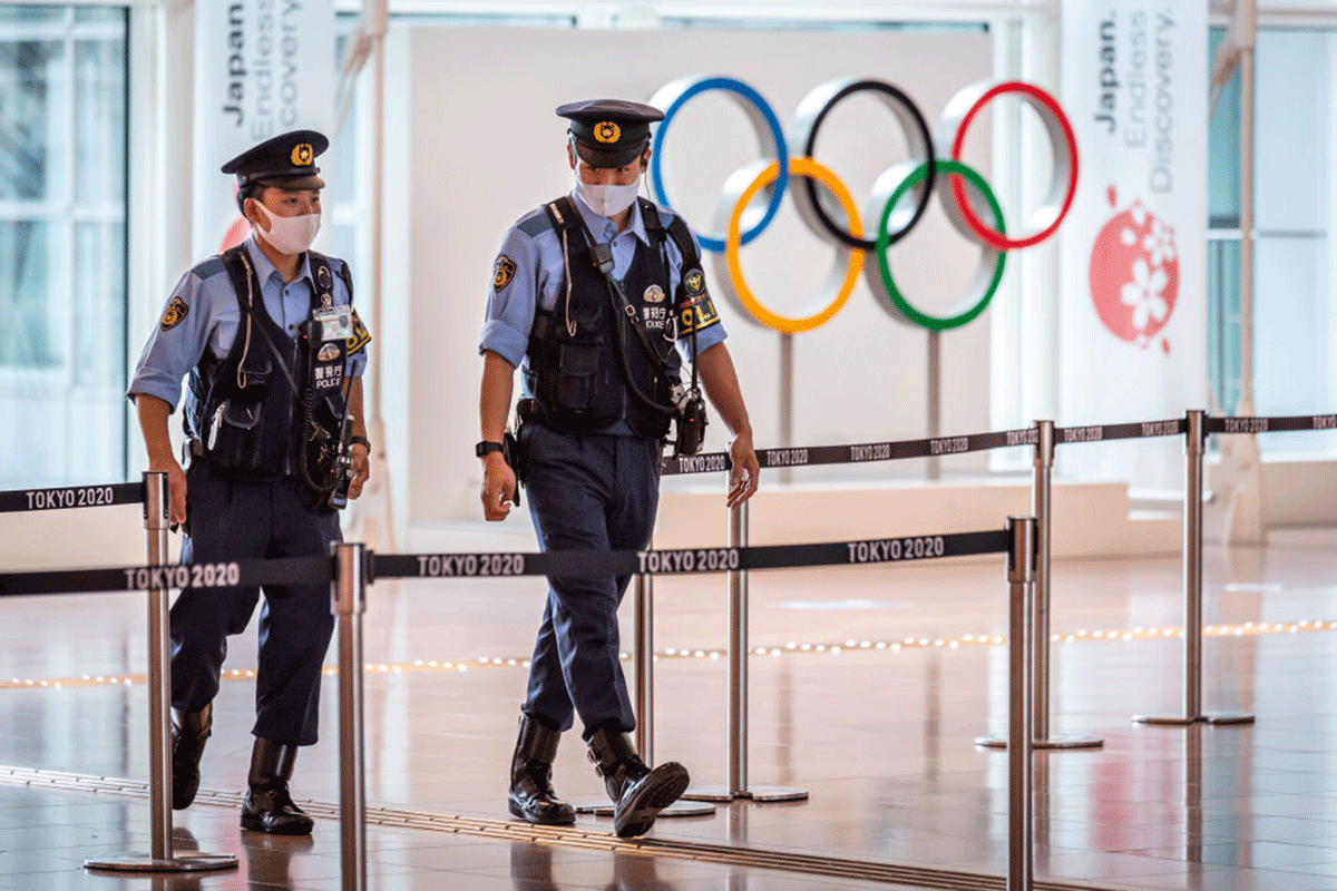 Police officers patrol around the arrival gate at Haneda airport in Tokyo on Tuesday Following a surge in coronavirus infections in Tokyo, the government has placed the capital in its fourth state of emergency as large numbers of foreign visitors arrive for the Olympics.