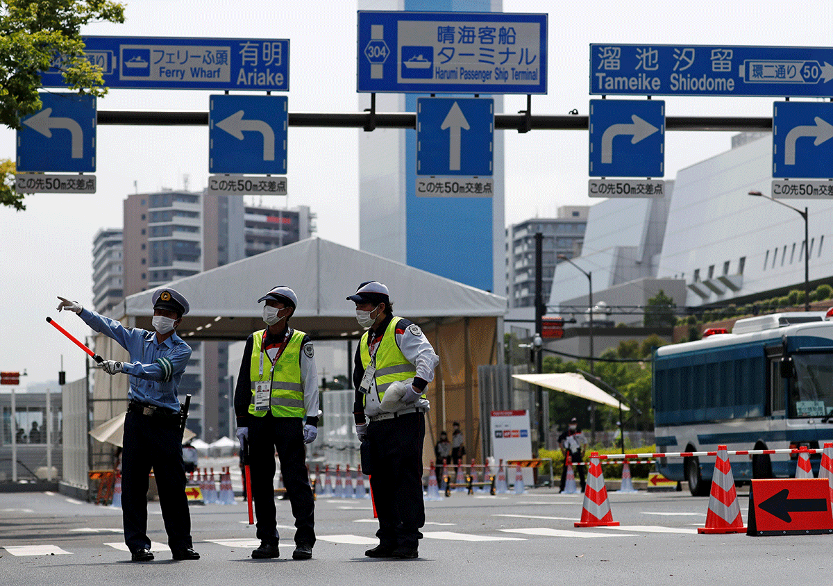 Police officers and security personnel stand guard at the entrance of the Athletes Village ahead of the Tokyo 2020 Olympic Games on Tuesday