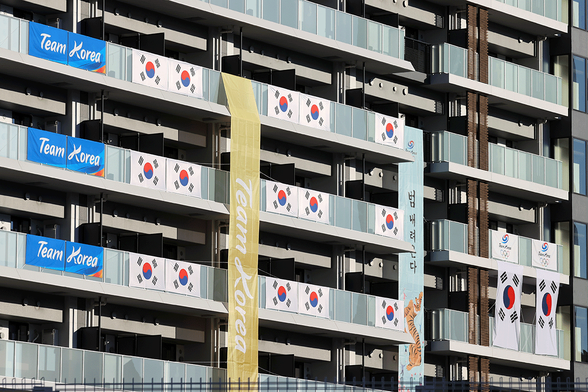 South Korean Flags and signs hang on the appartment building hosting Olympics participants, at the Athletes Village, where a person has tested positive for COVID-19, ahead of Tokyo 2020 Olympic Games in Tokyo on Saturday
