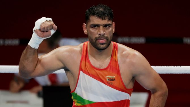 India's Satish Kumar celebrates victory over Jamaica's Ricardo Brown in the men's Super Heavyweight last 16 bout, at Kokugikan Arena in Tokyo, on Thursday.