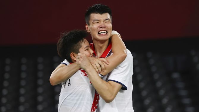China's Wang Yilyu and Huang Dongping celebrate winning the Olympics gold medal mixed doubles match against compatriots Zheng Siwei and Huang Yaqiong