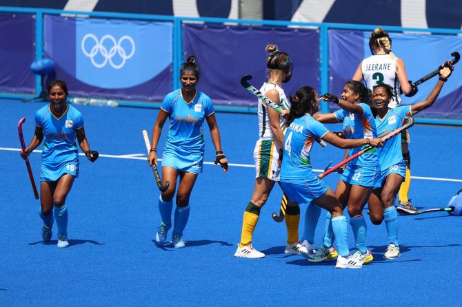 Neha Goyal celebrates with teammates after scoring India's third goal.