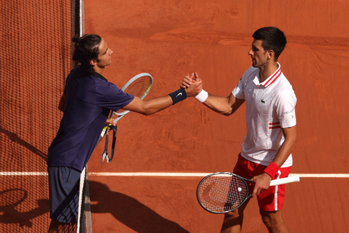 Lorenzo Musetti embraces Novak Djokovic after he retires through injury