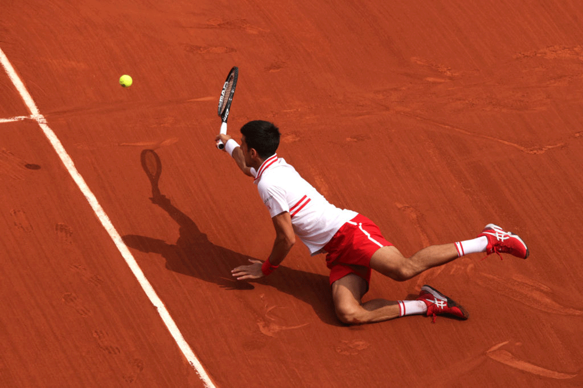 Novak Djokovic dives as he plays a return