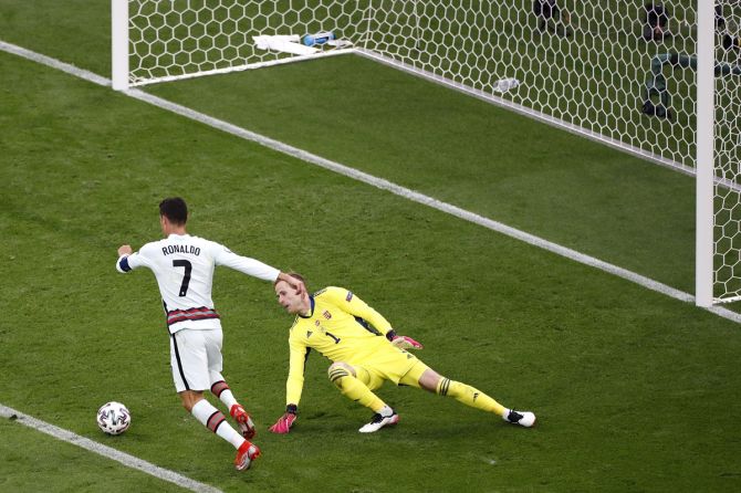 Cristiano Ronaldo goes around Hungary goalkeeper Peter Gulacsi  before scoring Portugal's third goal