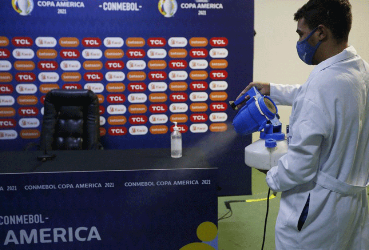 A staff member disinfects the press room at the Arena Pantanal, Cuiaba, Brazil. Brazil's Ministry of Health said on Monday that 31 players and Copa America delegation members had tested positive for COVID-19 by Monday another 10 cases were confirmed among employees working at hotels where the players and their delegations are staying in Brasilia. In total 33 players or officials from Venezuela, Colombia and Bolivia have tested positive since Sunday, the day the soccer tournament kicked off in four Brazilian cities.